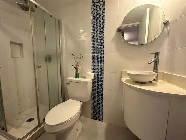 a bathroom with a toilet a sink and mirror