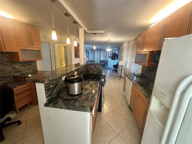 a kitchen with a sink stainless steel appliances a counter top space and cabinets