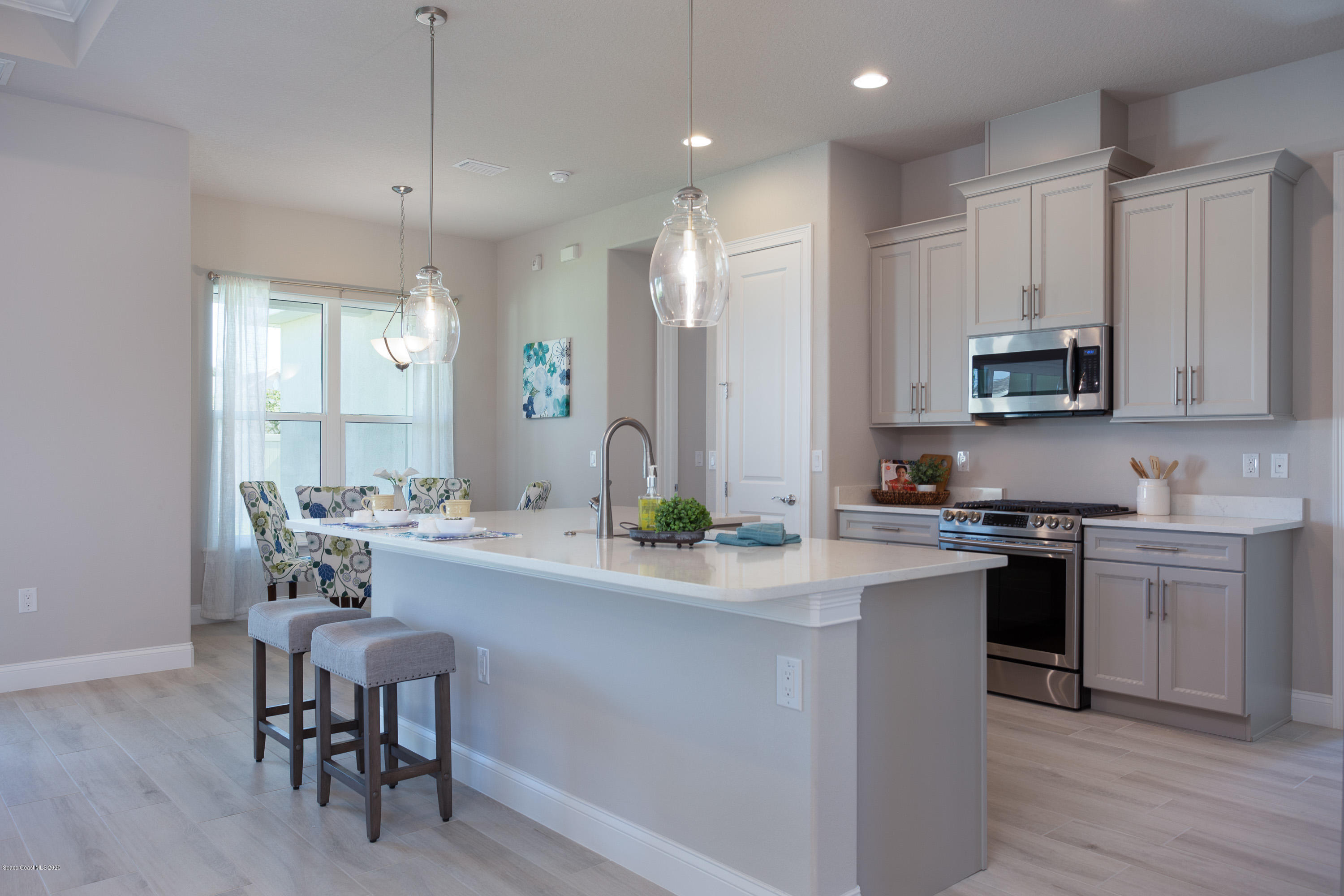 4435 Negal Circle Melbourne, FL 32901 - Photo 12 of 33 a kitchen with kitchen island granite countertop a sink a stove a dining table and chairs