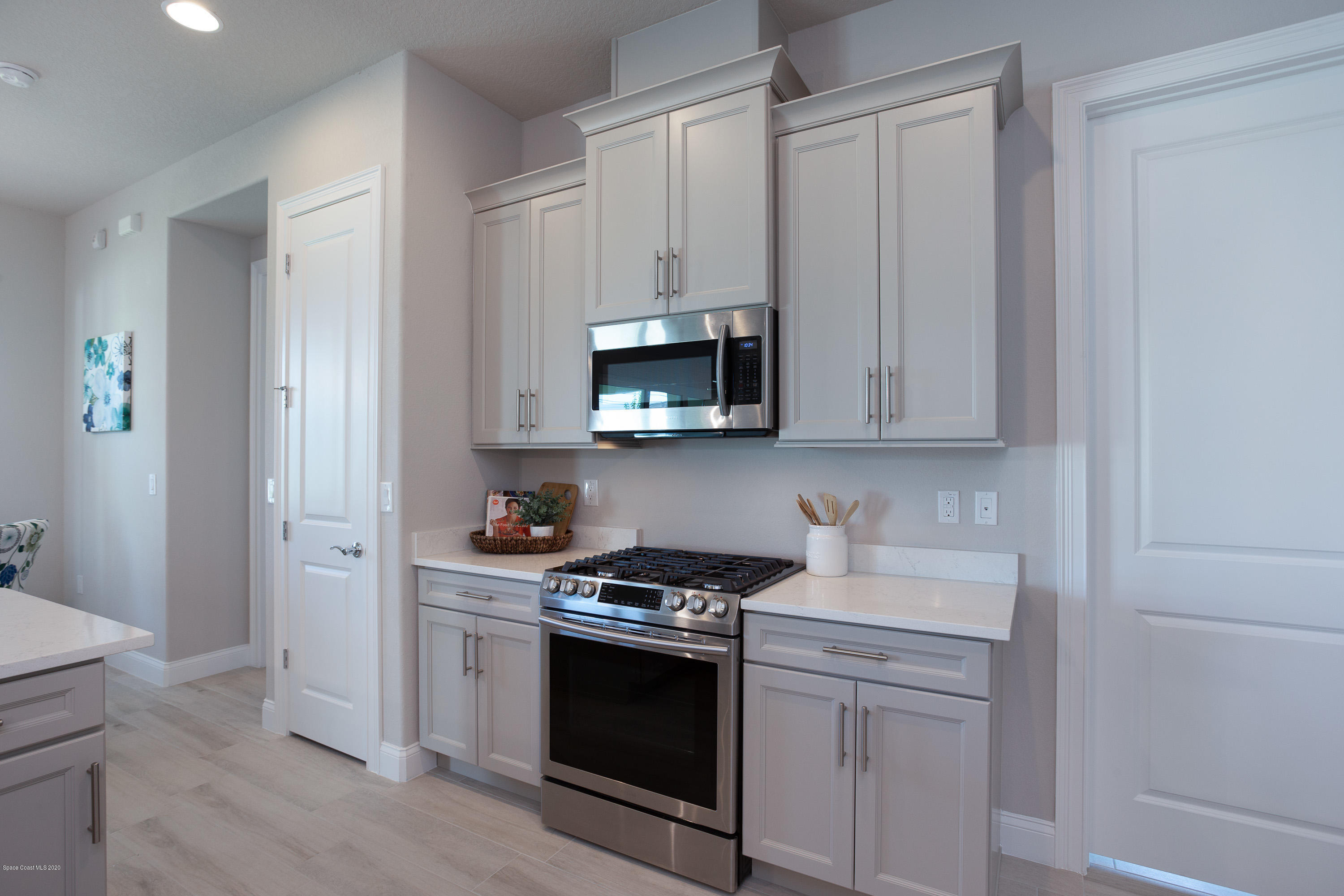 4435 Negal Circle Melbourne, FL 32901 - Photo 13 of 33 a kitchen with granite countertop white cabinets and stainless steel appliances