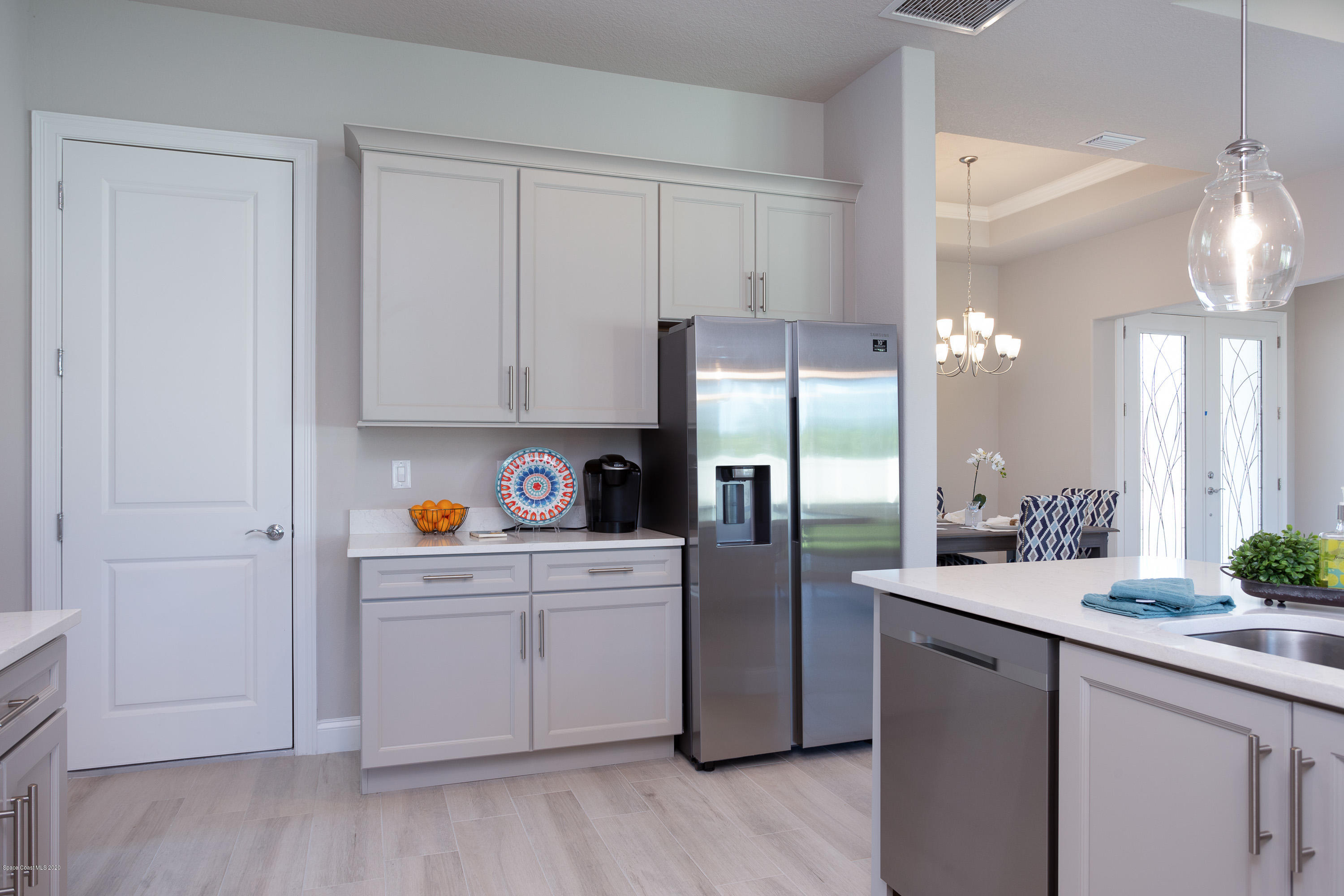 4435 Negal Circle Melbourne, FL 32901 - Photo 15 of 33 a kitchen with kitchen island white cabinets and refrigerator