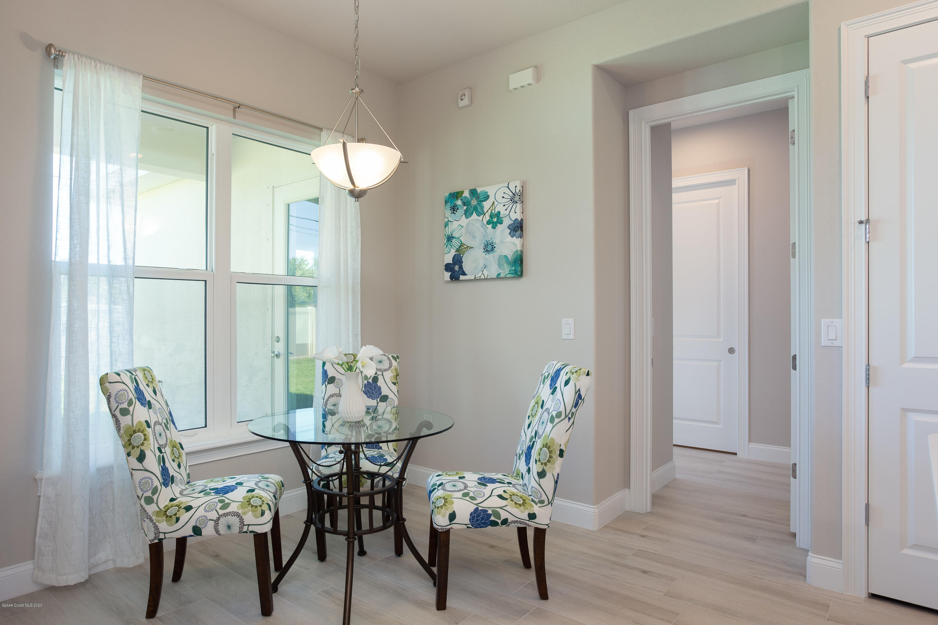 4435 Negal Circle Melbourne, FL 32901 - Photo 17 of 33 a dining room with furniture potted plants and wooden floor