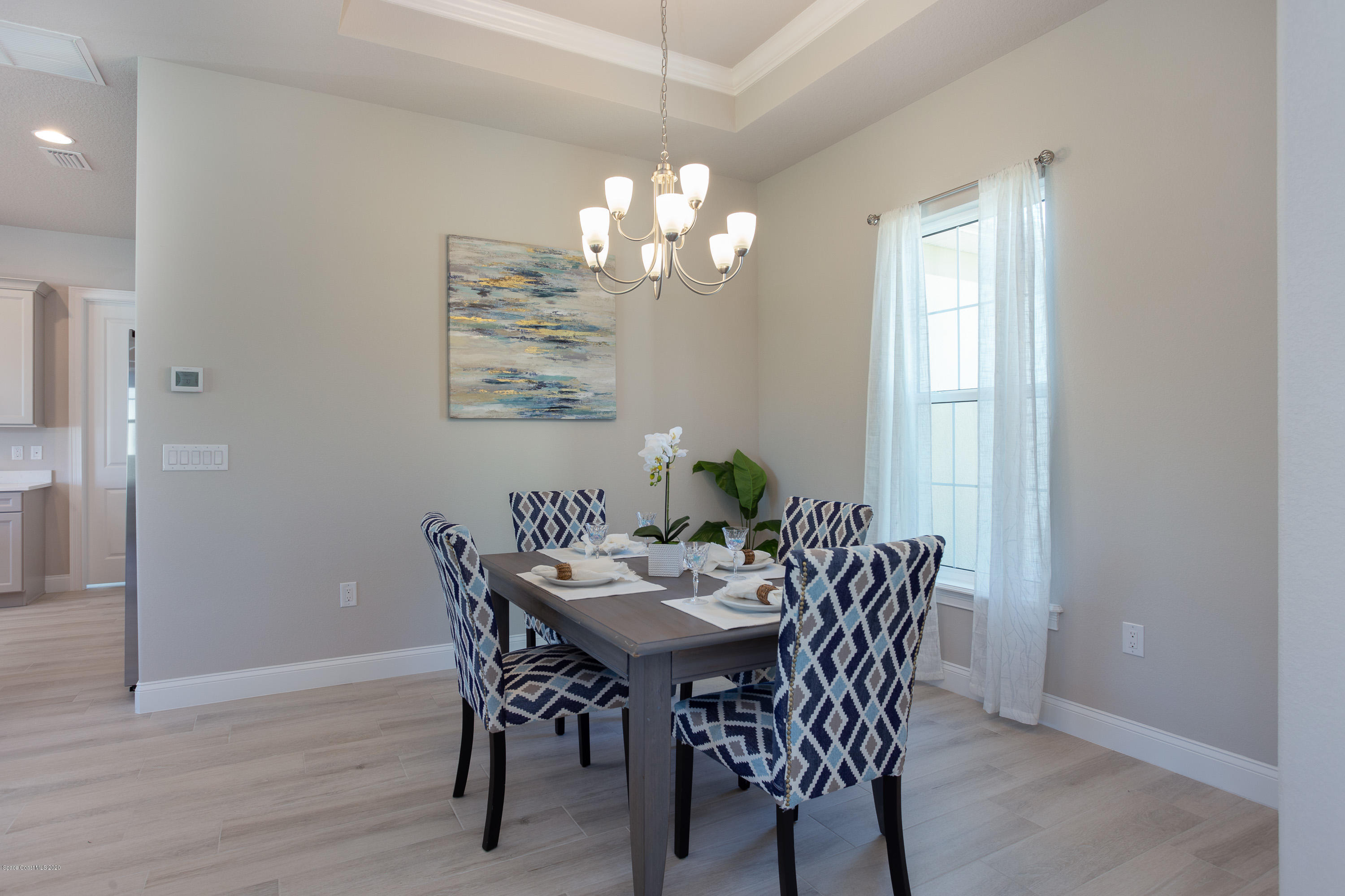 4435 Negal Circle Melbourne, FL 32901 - Photo 6 of 33 a view of a dining room with furniture a chandelier and wooden floor