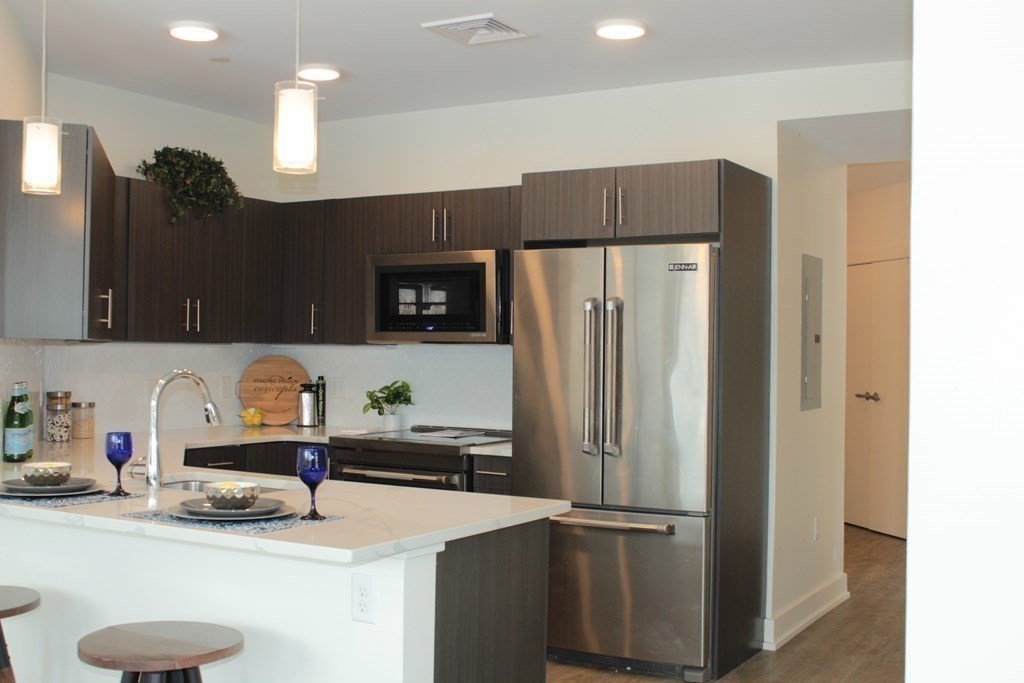 a kitchen with stainless steel appliances a refrigerator sink and microwave