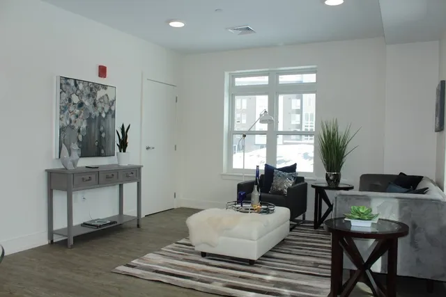 a living room with furniture a window and a potted plant