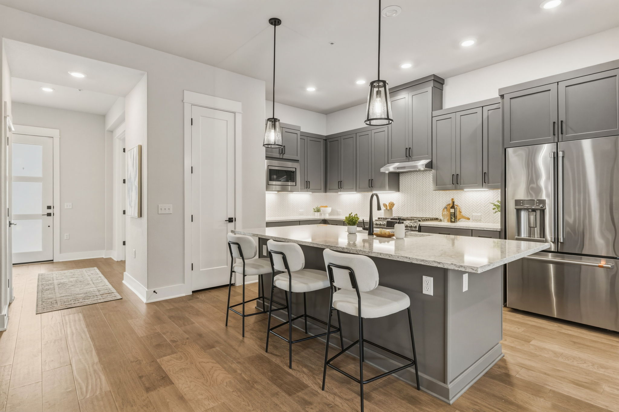 2929 Moreno Street Austin, TX 78723 - Photo 10 of 40 Contemporary kitchen featuring grey cabinetry, stainless steel appliances, and a central island with countertop seating