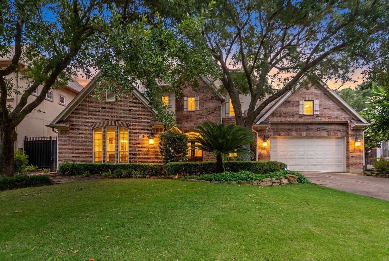a front view of a house with a yard and trees