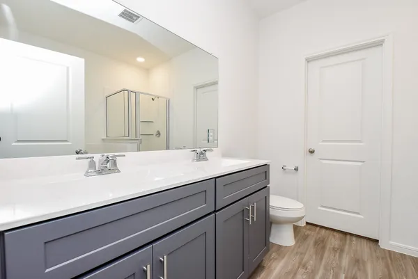 a bathroom with a granite countertop sink a toilet and a mirror