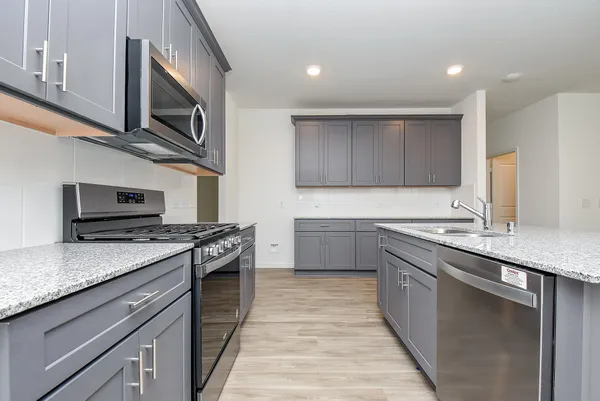a kitchen with stainless steel appliances granite countertop a sink and stove top oven