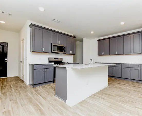 a kitchen with stainless steel appliances a sink a stove a microwave and cabinets