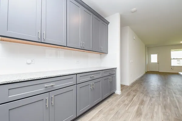 a view of a kitchen with cabinets and wooden floor
