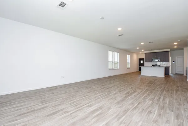 a view of empty room with wooden floor and window
