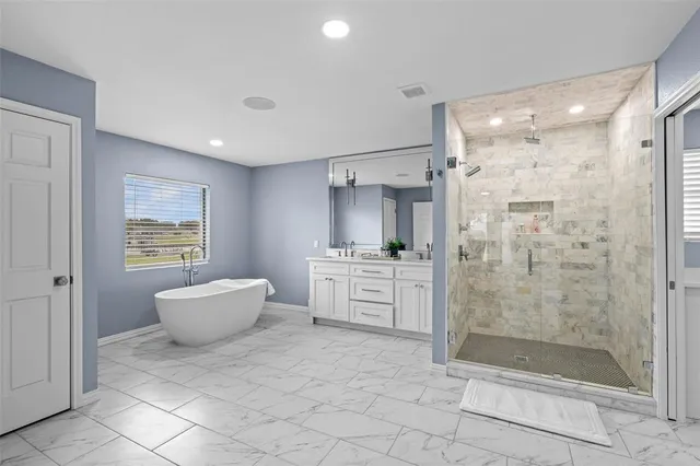 a bathroom with a bathtub shower sink and mirror