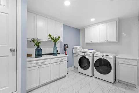 a utility room with sink dryer and washer