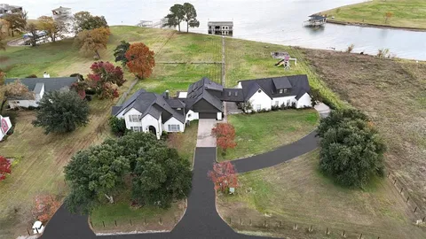 an aerial view of a house with a yard and lake view