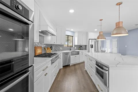 a kitchen with white cabinets and stainless steel appliances