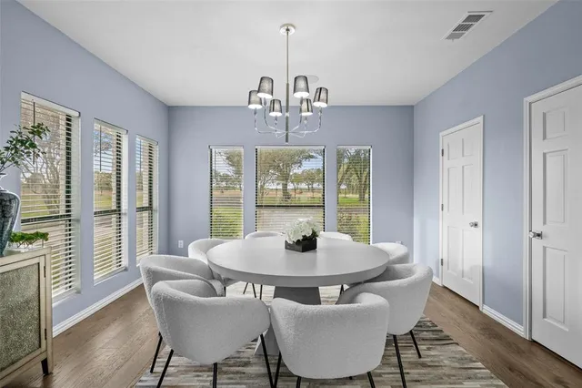 a dining room with furniture a chandelier and wooden floor