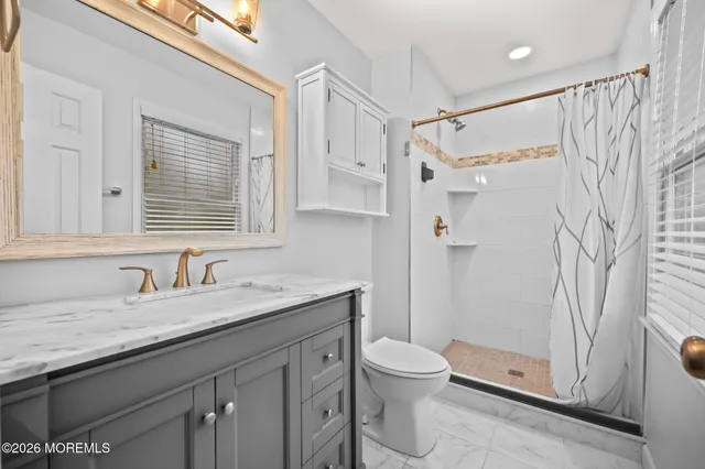 a bathroom with a granite countertop sink toilet and shower