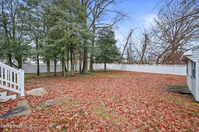 a view of a yard with wooden fence