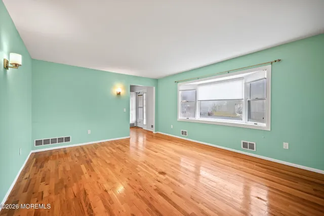 a view of a room with wooden floor and natural light