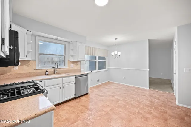 a large kitchen with kitchen island a sink stainless steel appliances and cabinets