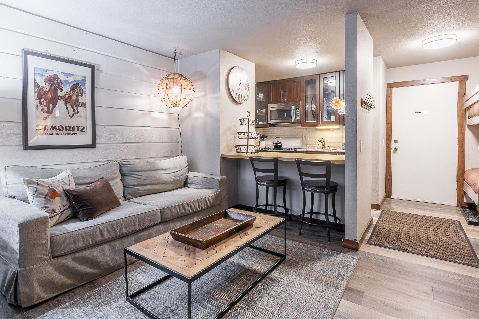 a living room with furniture a rug and kitchen view