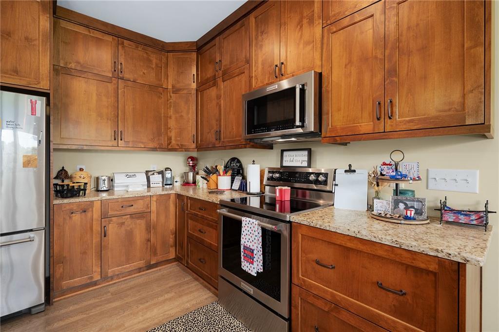 455 Poarch Farm Road Northeast Ranger, GA 30734 - Photo 52 of 93 a kitchen with stainless steel appliances granite countertop a stove top oven a sink dishwasher and cabinets with wooden floor