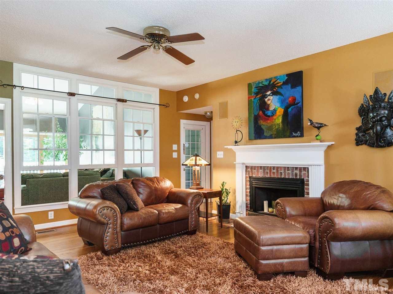 533 Rand Road Raleigh, NC 27603 - Photo 3 of 25 a living room with furniture ceiling fan and a fireplace