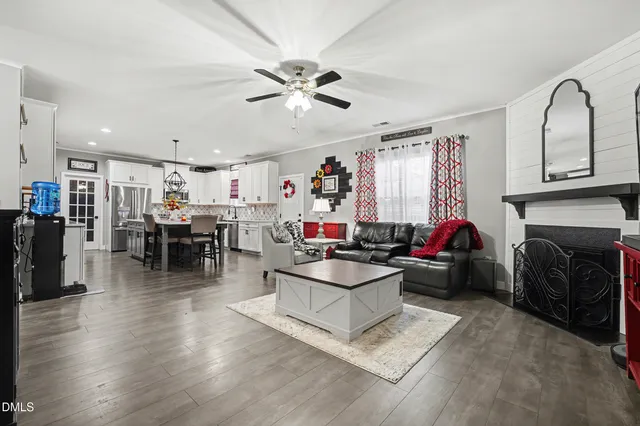 a open kitchen with a stove a refrigerator and a dining table with wooden floor