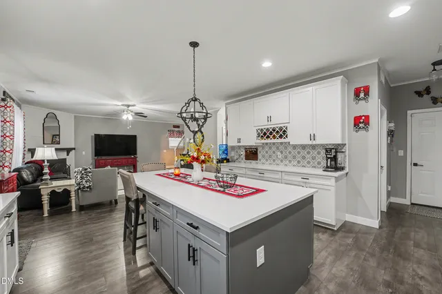 a kitchen with a dining table chairs stove and white cabinets