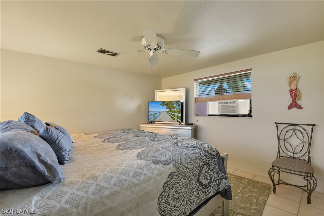 5970 Adele Court Fort Myers, FL 33919 - Photo 14 of 28 a bedroom with a bed and wooden floor