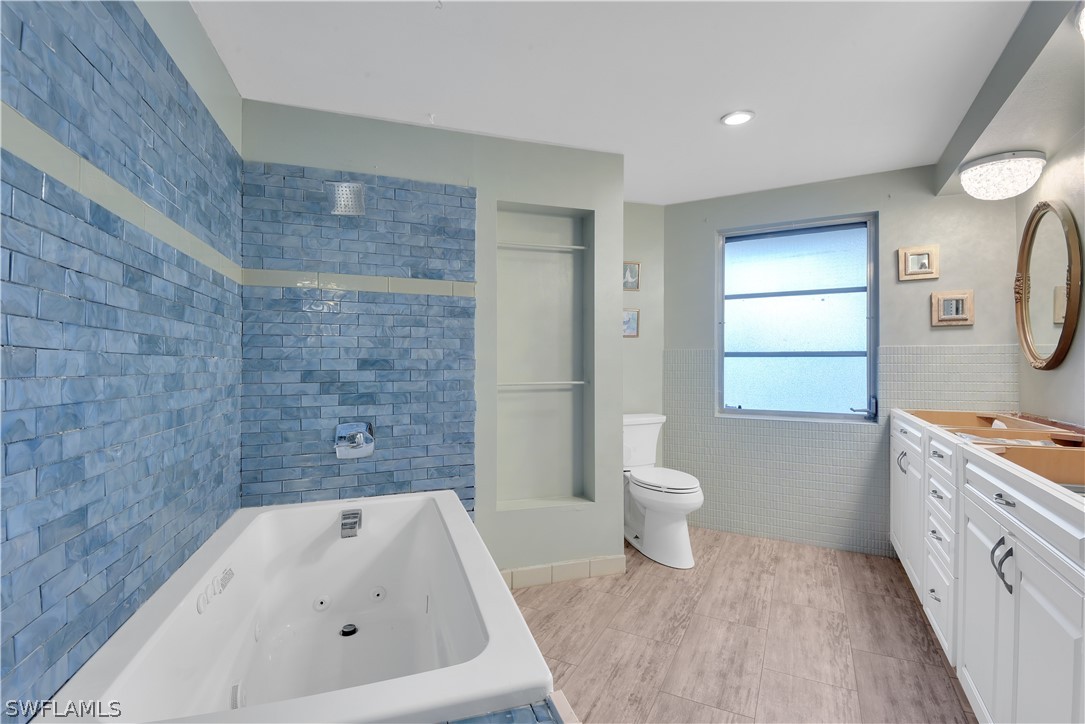 5970 Adele Court Fort Myers, FL 33919 - Photo 16 of 28 a bathroom with a granite countertop sink a toilet and a bathtub