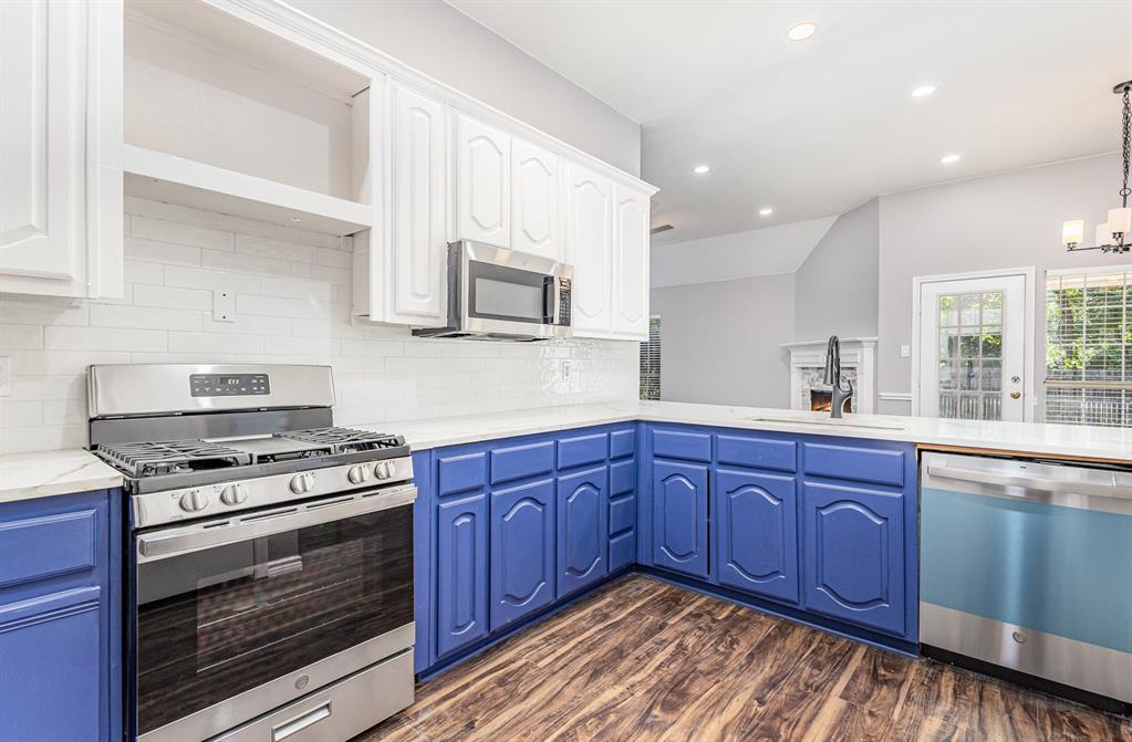 3674 Crowberry Way Fort Worth, TX 76040 - Photo 15 of 26 Kitchen featuring stainless steel appliances, white cabinets, recessed lighting, dark wood finished floors, and decorative backsplash