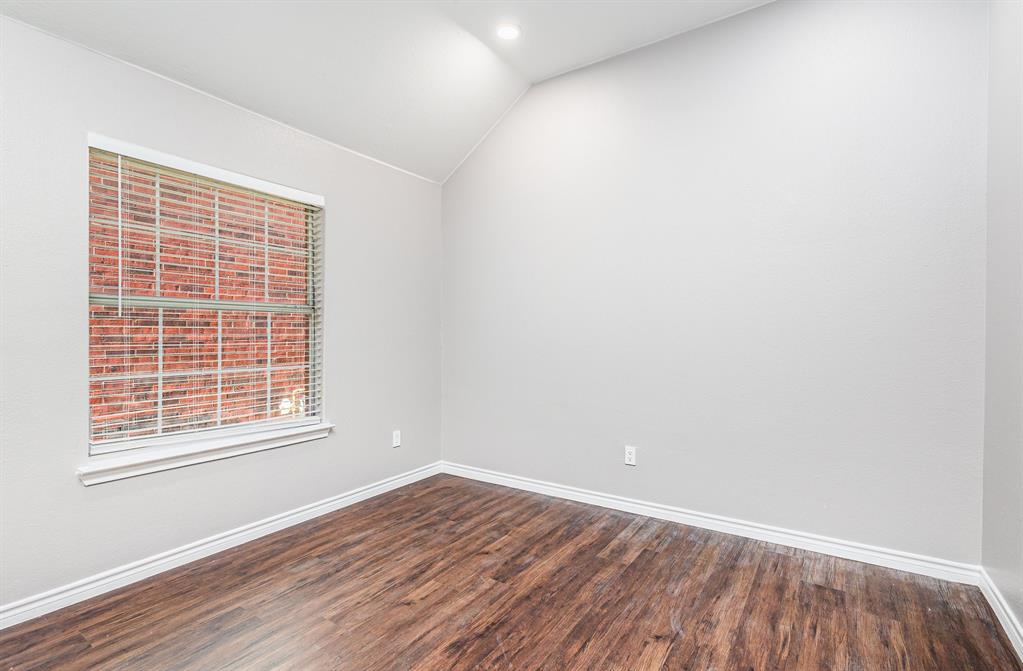 3674 Crowberry Way Fort Worth, TX 76040 - Photo 21 of 26 Empty room featuring vaulted ceiling, dark wood-style floors, and recessed lighting