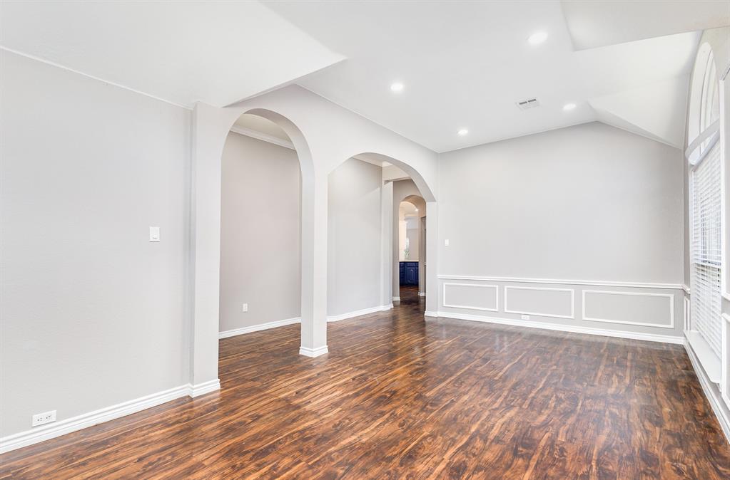 3674 Crowberry Way Fort Worth, TX 76040 - Photo 8 of 26 Empty room with wood finished floors, recessed lighting, vaulted ceiling, and arched walkways