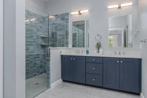 a bathroom with a sink shower and a mirror