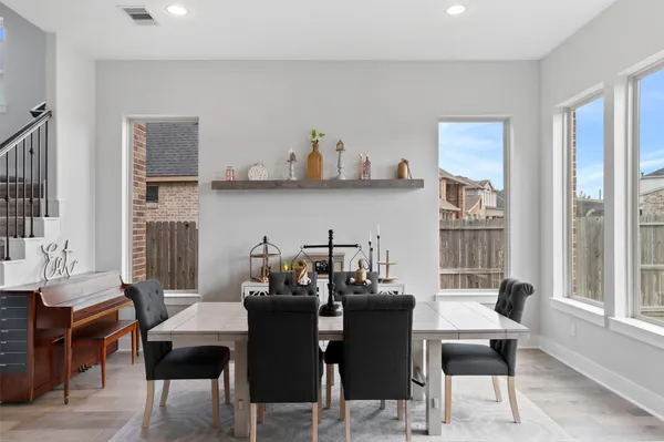 a view of a dining room with furniture large windows and wooden floor