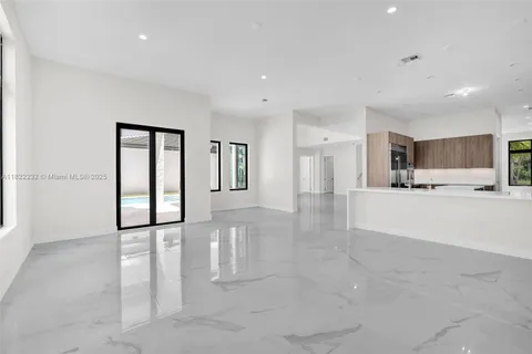 a large white kitchen with cabinets a sink and a stove