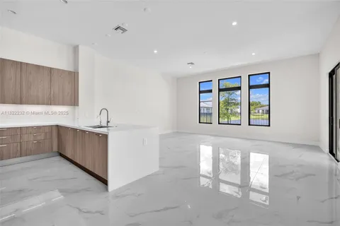 a kitchen with stainless steel appliances kitchen island granite countertop a refrigerator and a sink