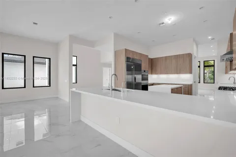 a kitchen with granite countertop a refrigerator and windows