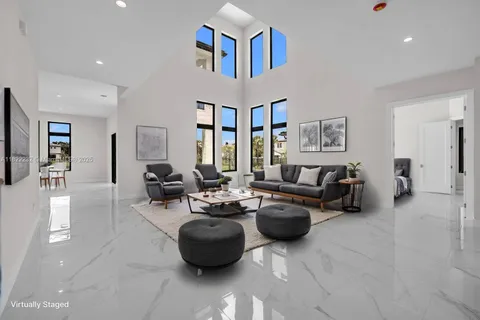a living room with furniture a large window and a chandelier