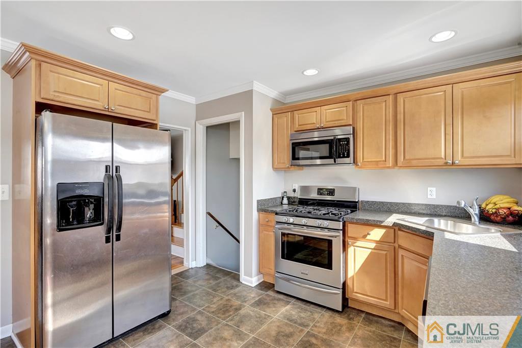 675 Colonial Arms Road Union, NJ 07083 - Photo 9 of 25 a kitchen with stainless steel appliances granite countertop a refrigerator a stove a sink and a microwave