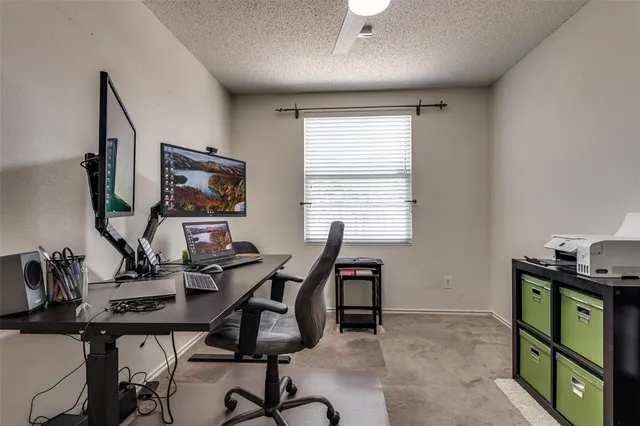 a view of a workspace with furniture and a window