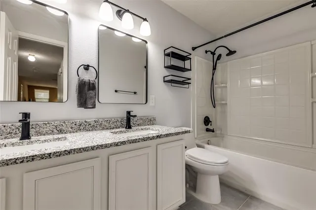 a bathroom with a toilet sink double vanity and shower