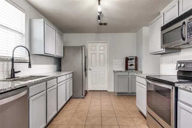 a kitchen with stainless steel appliances granite countertop a sink and cabinets