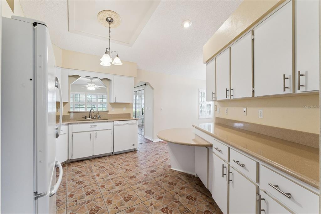 27217 Racquet Circle Leesburg, FL 34748 - Photo 14 of 90 a large kitchen with kitchen island white cabinets and stainless steel appliances