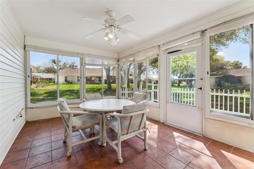 27217 Racquet Circle Leesburg, FL 34748 - Photo 29 of 90 a dining room with furniture large windows and wooden floor
