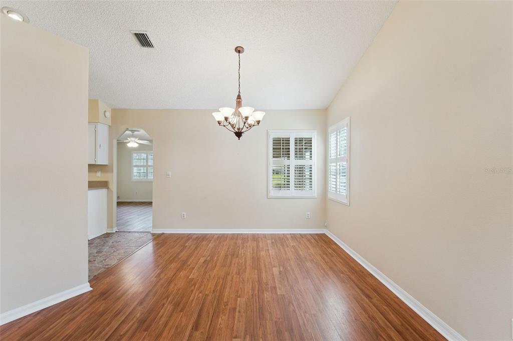 27217 Racquet Circle Leesburg, FL 34748 - Photo 10 of 90 a view of a room with wooden floor staircase and a kitchen