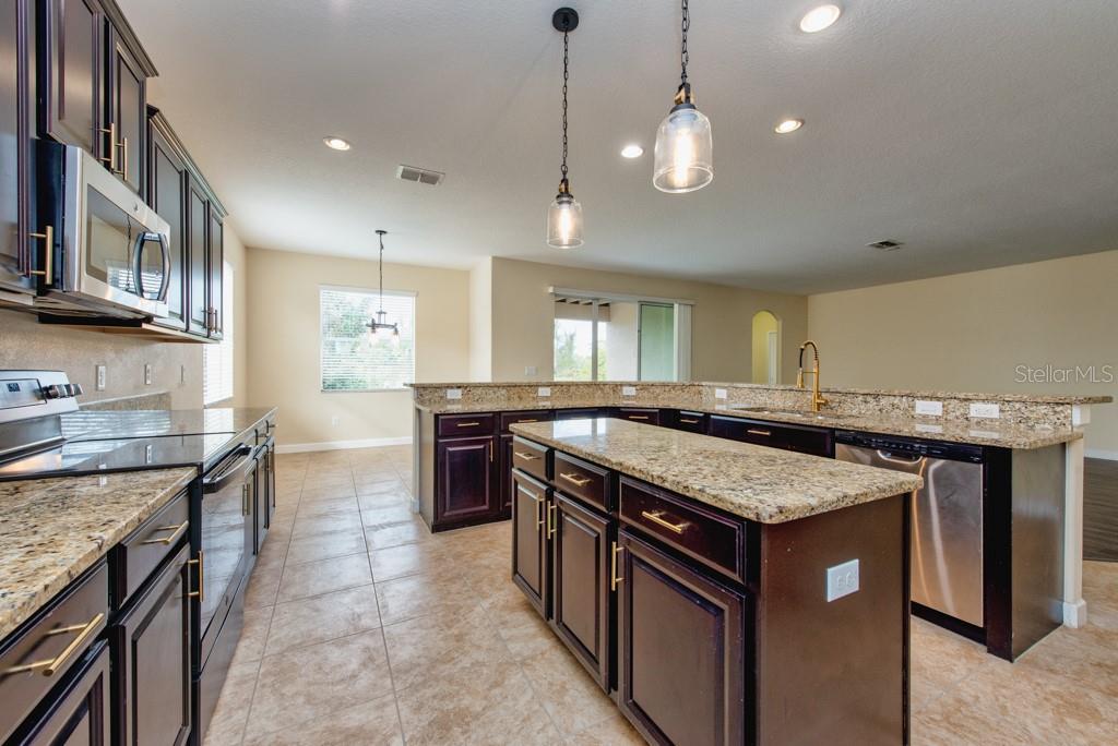 2409 Allegheny Valley Street Ruskin, FL 33570 - Photo 12 of 53 a kitchen with stainless steel appliances granite countertop a stove a sink a oven and a refrigerator