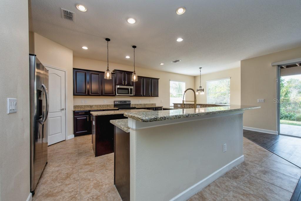 2409 Allegheny Valley Street Ruskin, FL 33570 - Photo 14 of 53 a kitchen with kitchen island granite countertop stainless steel appliances cabinets a sink and a counter top space